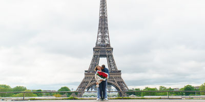 Couple avec bouquet de roses devant la Tour Eiffel depuis la place du Trocadéro, Paris, demande en mariage