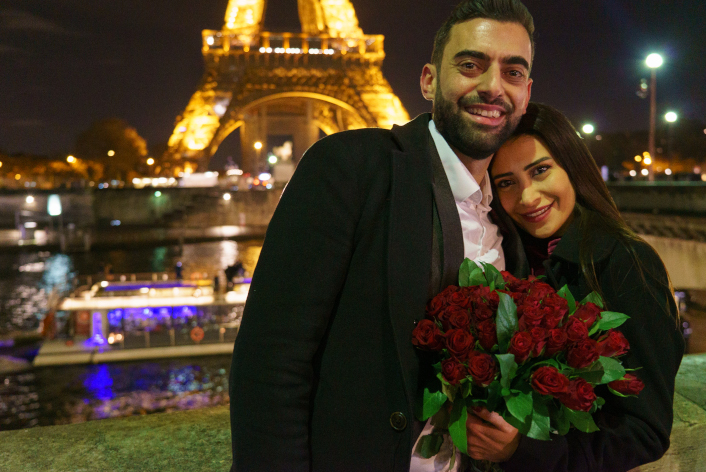 Couple avec un bouquet de roses, demande en mariage devant la Tour Eiffel, port Debilly, Paris France, de nuit