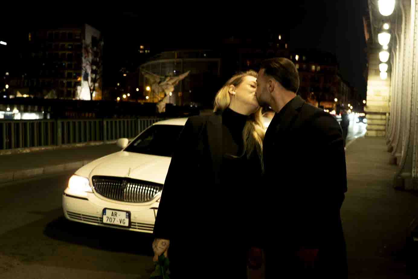 Photographe à Paris : couple célébrant une demande en mariage sur le pont Bir-Hakeim de nuit.