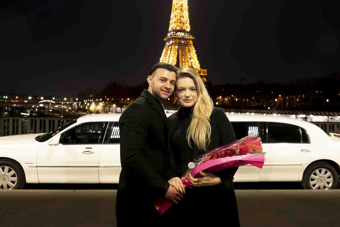 Photographe demande en mariage Paris : couple avec bouquet de roses sur le Pont Bir-Hakeim.
