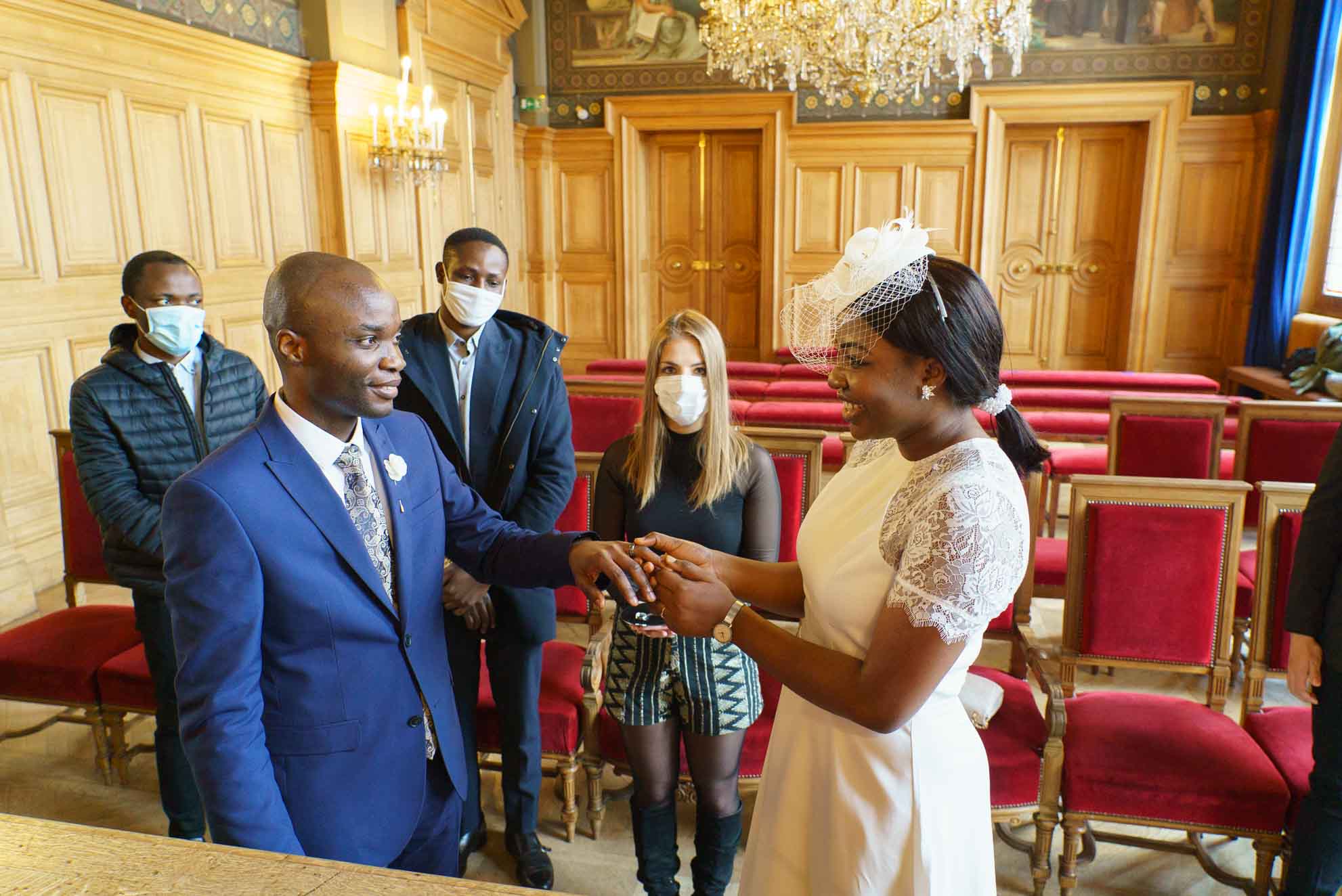 Photographe mariage Paris 13e – Photo des alliances échangées lors de la cérémonie de mariage à la mairie de Paris 13e, couple de mariés avec invités