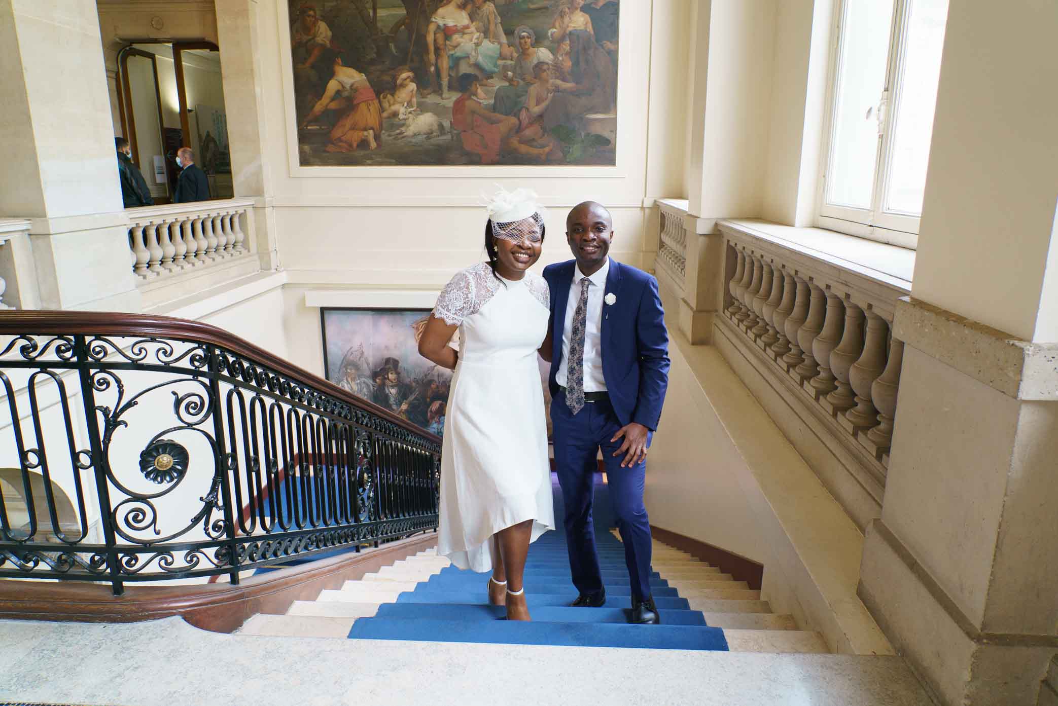 Photo de mariage en noir et blanc – Couple de mariés montant l'escalier de la mairie du 13e arrondissement de Paris, par un photographe de mariage professionnel