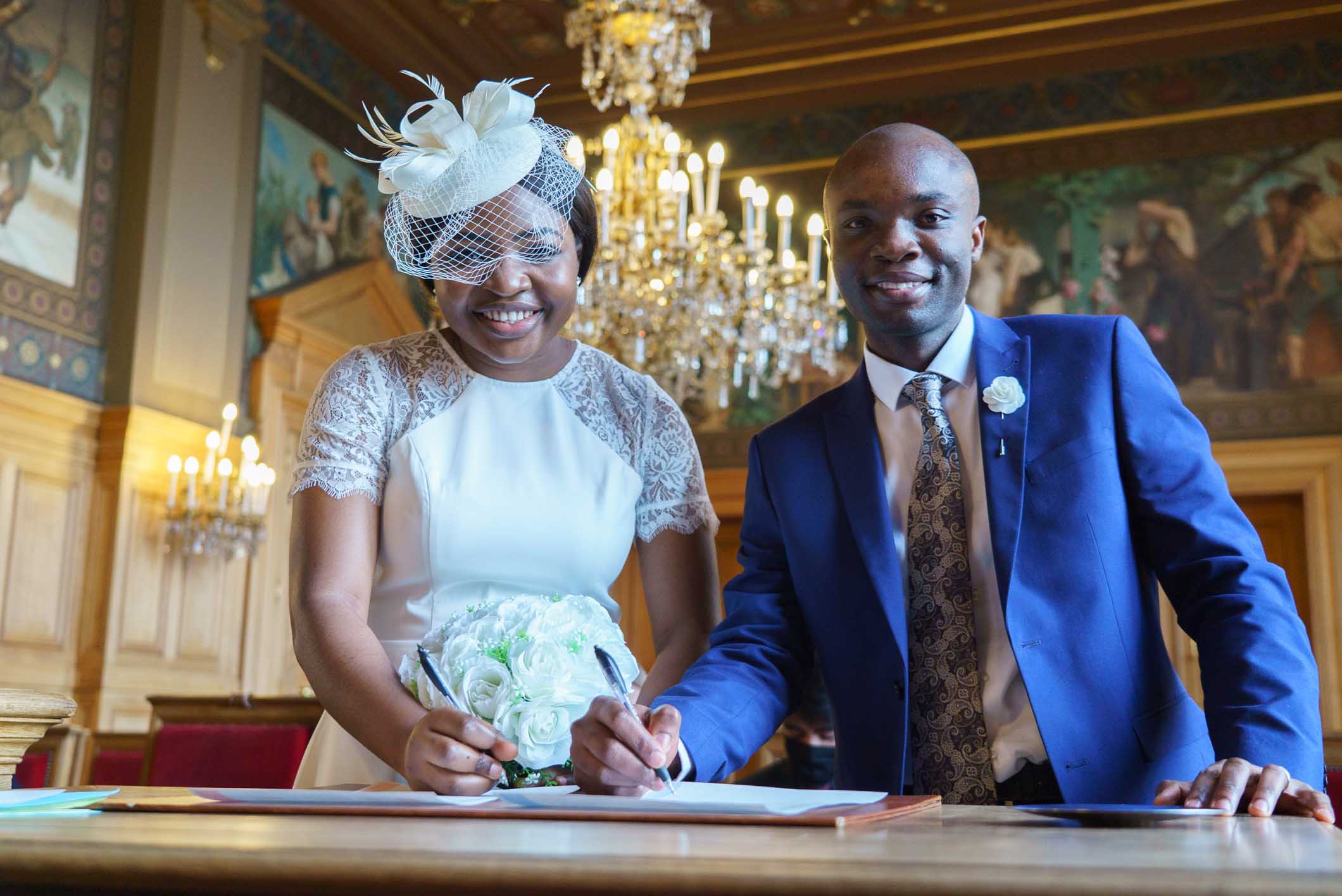 Photographe mariage Paris 13e – Signature du registre de mariage par le couple de mariés à la mairie du 13e arrondissement de Paris