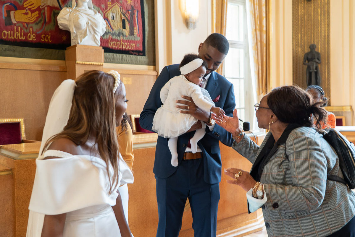 Le couple de mariés entouré de leur bébé et famille dans la salle de mariage