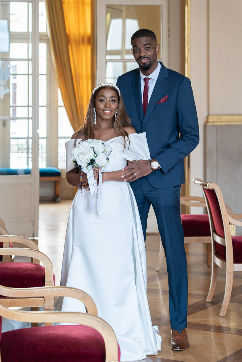 Photo romantique du couple de mariés devant la mairie de Paris