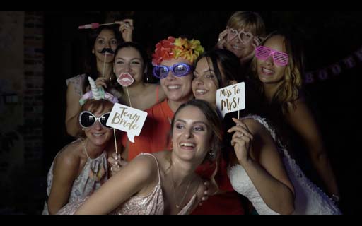 photos de groupe drôle de filles portant des accéssoires de déguisement avec la mariée posant devant un photo booth
