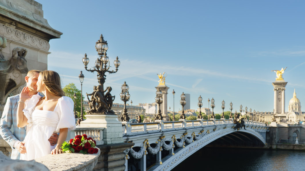 Couple sur le pont Alexandre III à Paris, candélabres en arrière-plan